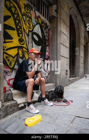 A drunk homeless beggar in the street of the city of Barcelona, Spain Stock Photo