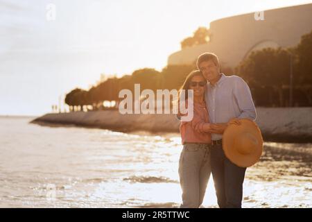 Happy Middle Aged Couple Embracing On The Beach At Sunset Stock Photo