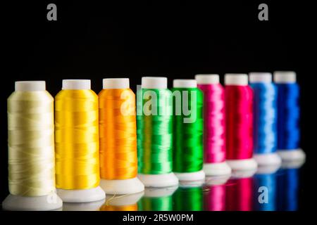 set of different color sewing threads, isolated on black background. Stock Photo