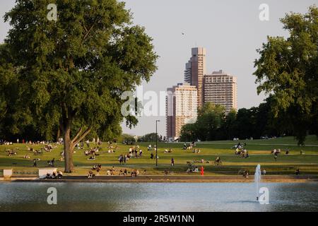 Cologne, Germany. 05th June, 2023. People enjoy the evening sun on a meadow at the Aachener Weiher, the Uni-Center can be seen in the background. Credit: Rolf Vennenbernd/dpa/Alamy Live News Stock Photo