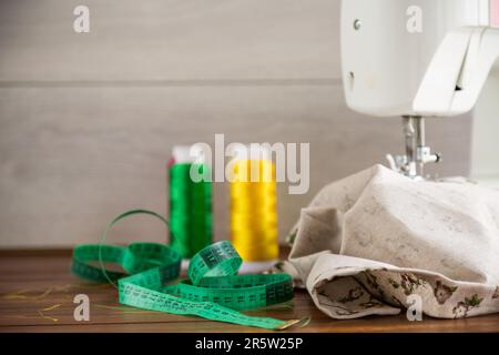 Sewing machine with fabric and threads for sewing, close-up. The working process. Part of a sewing machine with fabric. Stock Photo