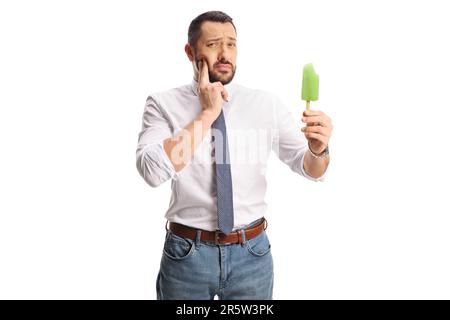 Young man with a lollipop ice cream holding his cheek and having a toothache isolated on white background Stock Photo