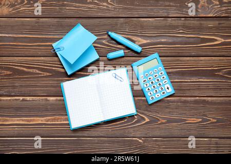 Sticky notes with notebook and calculator on brown wooden background Stock Photo