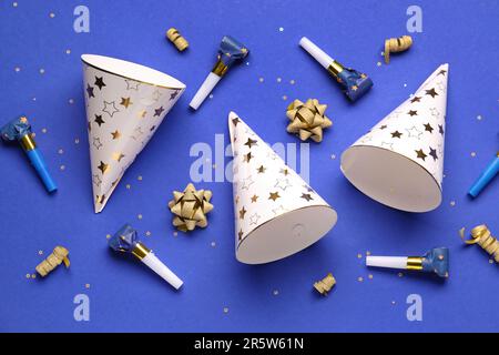 Party hats and whistles on dark blue background Stock Photo - Alamy
