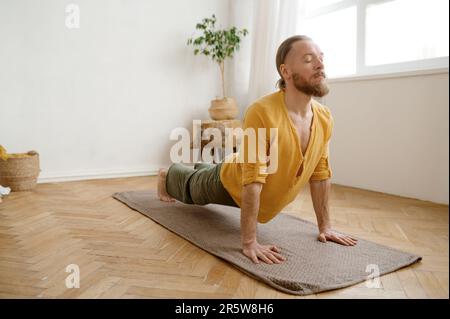 Young athletic man standing in Urdhva Mukha Svanasana yoga pose Stock Photo