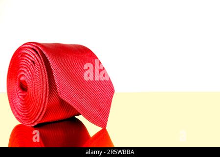 A close-up shot of a man's necktie draped over a brown leather bag, showcasing the colors and textures of both items Stock Photo