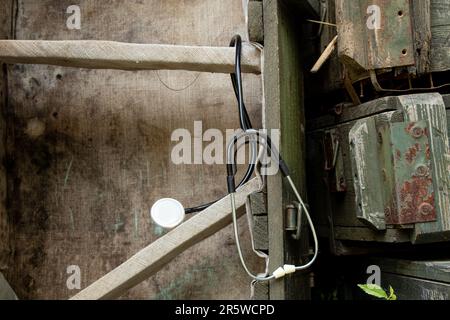 A stethoscope hangs on green ammunition boxes in the war, a military doctor, diagnostics Stock Photo