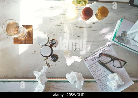 The get well soon starter pack. High angle shot of medication, tissues a notepad and glasses on a table at home. Stock Photo