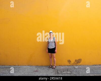 Canadian Woman Poses for the Camera on a Yellow Background in Cartagena de Indias, Colombia Stock Photo