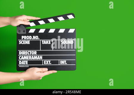 Hands holding a clapper while filming a video movie on TV. A clapper ...