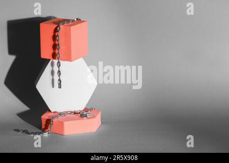 Elegant jewelry. Stylish presentation of luxury bracelets and ring on podiums against gray background. Space for text Stock Photo