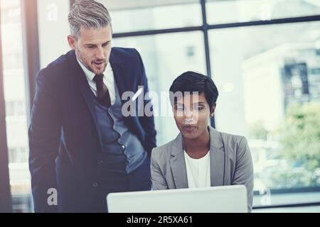 Their individual skill sets complement each other. a businesswoman and businessman using a laptop together at work. Stock Photo
