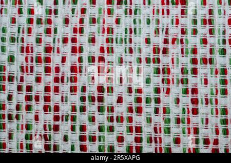 Red, Green and White vintage yarn pattern background. Abstract retro textile fabric backdrop. Bright, colorful woven design. Stock Photo