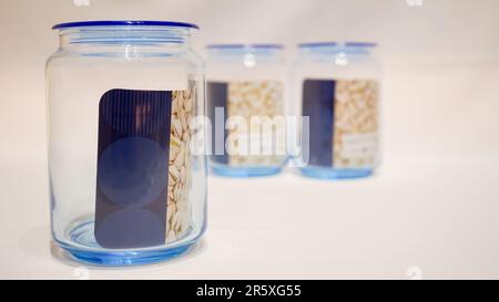 The Set of Three Blue-Lidded Jars is a charming and functional addition to any storage space. These jars come in a set of three, each with a blue lid Stock Photo