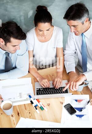 Working together on their presentation. Group of businesspeople working together on a project. Stock Photo