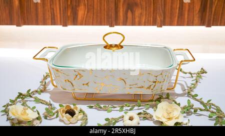 This Rectangular White Ceramic Vegetable Container with Gold Motif is a stunning addition to your kitchen collection. Stock Photo