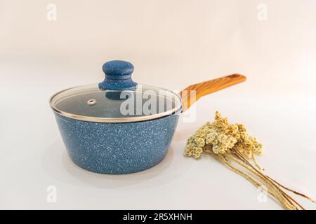 The Blue Pot and Fry Pan with Wooden Handle is a versatile and convenient cookware set that combines functionality with style. Stock Photo