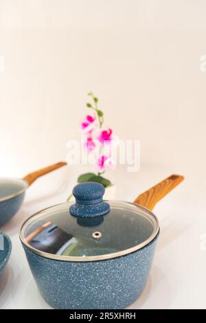 The Blue Pot and Fry Pan with Wooden Handle is a versatile and convenient cookware set that combines functionality with style. Stock Photo
