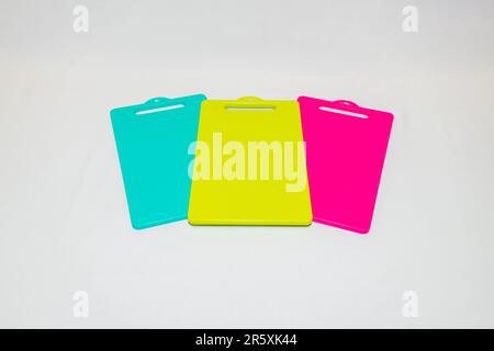 The Blue, Yellow, and Pink Plastic Cutting Board is a set of vibrant and practical kitchen essentials. Stock Photo