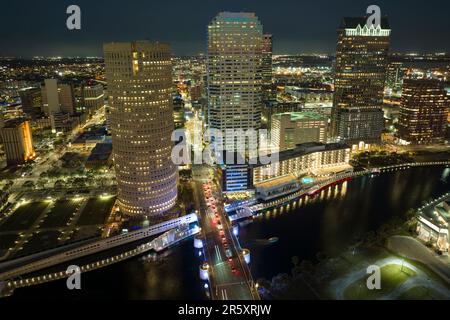 Aerial view of downtown district of Tampa city in Florida, USA. Brightly illuminated high skyscraper buildings, pedestrian riverwalk and moving Stock Photo