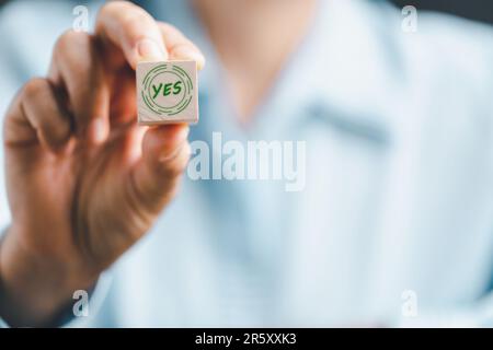 Concept of choice yes on wooden cubic blocks. Think with Yes or No choice, Business choices for difficult situations, Business woman hands holding woo Stock Photo