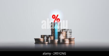 Stacked coins on wooden table with illustration shows increasing of interest rates, financial concept. Interest rate financial and mortgage rates. Ico Stock Photo