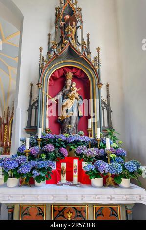 Side altar and figure of Mary with crown and baby Jesus in the church of St. Michael, one of the oldest churches in the Allgaeu, listed as a Stock Photo