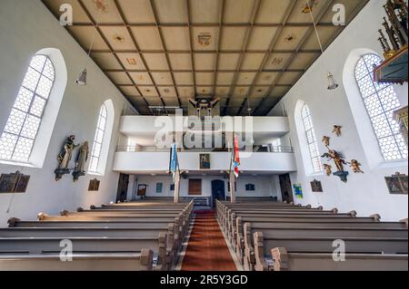 The organ loft of the Church of St. Michael with coffered ceiling and flags, one of the oldest churches in the Allgaeu, listed as a historical Stock Photo