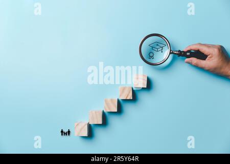 Hand holding a magnifying glass with education icons on a blue background. education concept. Creative idea and innovation. Stock Photo