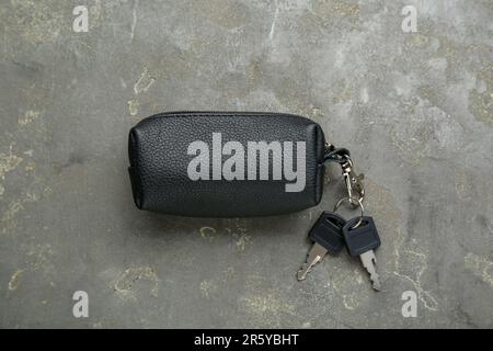 Leather case with keys on grey textured table, top view Stock Photo