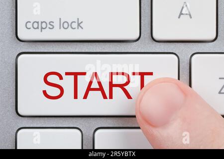 Woman pressing button with word Start on computer keyboard, closeup Stock Photo