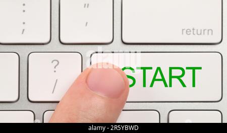 Man pressing button with word Start on computer keyboard, closeup Stock Photo