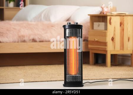Modern infrared heater on floor in cozy room Stock Photo