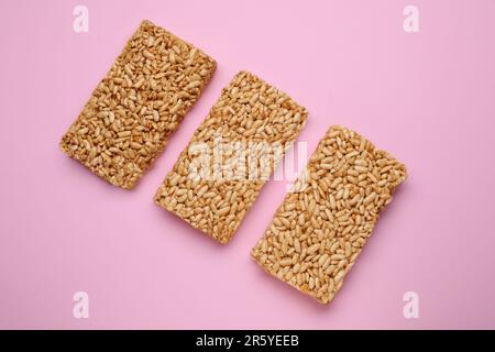 Puffed rice bars (kozinaki) on pink background, flat lay Stock Photo