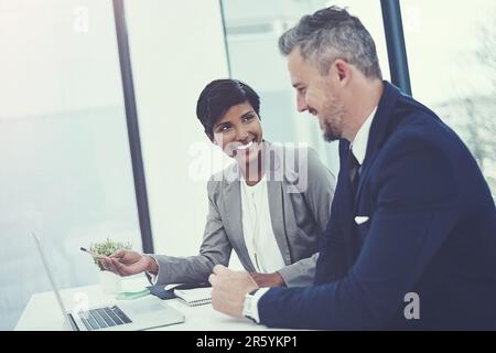 Work together, win together. a businesswoman and businessman using a laptop together at work. Stock Photo