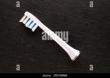 One head for an electric toothpick on slate stone, macro, top view. Stock Photo