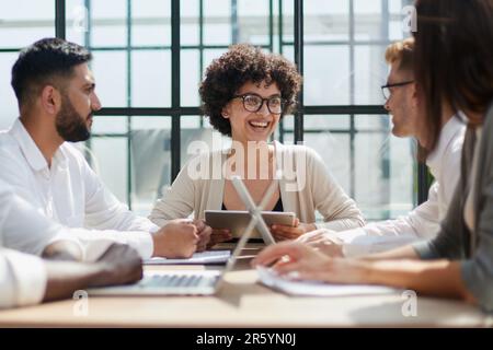 Employees working at computer together, discussing content Stock Photo