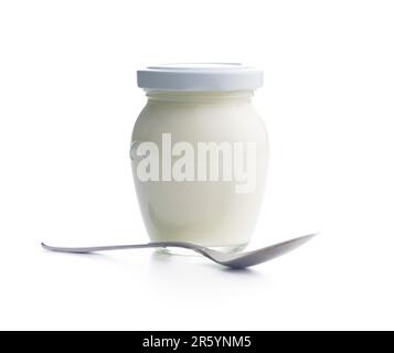 White yogurt in jar and spoon isolated on the white background. Stock Photo