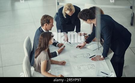 Excellence is all in the details. a team of corporate architects collaborating on a plan in a modern office. Stock Photo