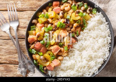 Homemade Hoppin john Southern style New year good luck food is a black-eyed peas and rice with vegetables dish closeup on the plate on the wooden tabl Stock Photo