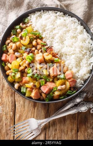 Hoppin john black eyed peas, sometimes called Carolina Peas and Rice, cooked with bacon, sausage, and veggies, and served over fluffy rice closeup. Ve Stock Photo