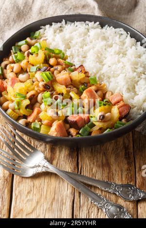 Hoppin John is one of those classic Southern dishes made of black-eyed peas and rice closeup on the plate on the wooden table. Vertical Stock Photo