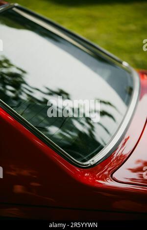 Color close up shot of the rear window of a vintage red car. Stock Photo