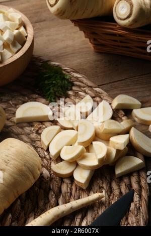 Whole and cut parsnips on wooden table Stock Photo