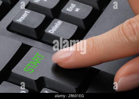 Woman pressing button with word Start on computer keyboard, closeup Stock Photo