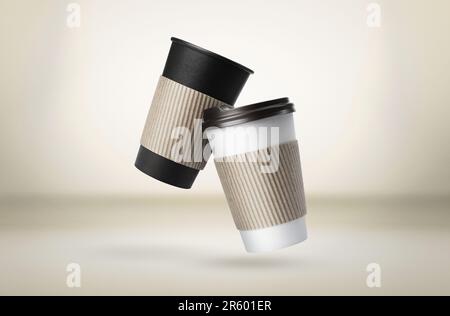 Takeaway paper cups falling on beige background Stock Photo