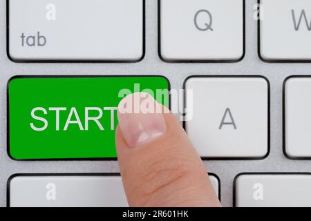 Woman pressing green button with word Start on computer keyboard, closeup Stock Photo