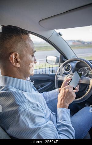 Driver using a mobile phone inside his car. Stock Photo