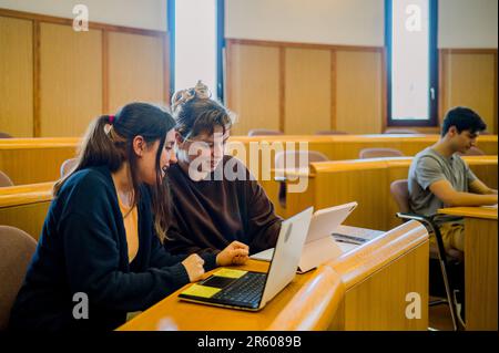 Team of woman students sitting at desk with laptop and tablet Stock Photo