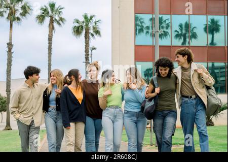 Group of happy multiracial students walking in campus Stock Photo